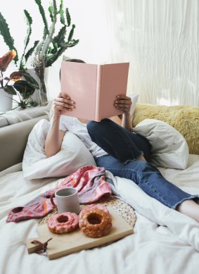 A comfy couch, doughnuts, coffee, and a book make this a pretty hyggelig nook. 
