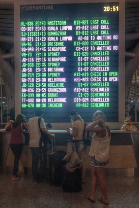 Passengers are seen checking the departure information board at Denpasar Airport on Tuesday night.