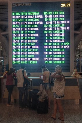 Passengers are seen checking the departure information board at Denpasar Airport on Tuesday night.