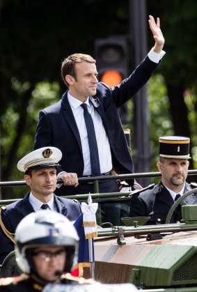 New French President Emmanuel Macron salutes the crowd on the Champs Elysees after the handover ceremony with outgoing President Francois Hollande.