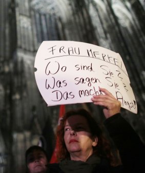 A woman protests against sexism outside the cathedral in Cologne, Germany, on Tuesday.  The poster reads "Mrs Merkel. Where are you? What do you say? It's scary".  