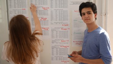 Victoriana Nicolitsi (left) and John Notaris check their results at the Experimental Senior High School of the University of Athens on Wednesday.