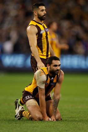 Paul Puopolo consoles Hawks teammate Shaun Burgoyne after the qualifying final loss to Geelong on Friday night. 