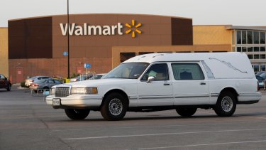A hearse sits in the parking lot of a Walmart store where eight people were found dead.