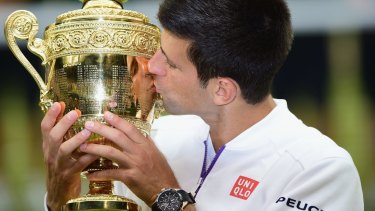 Djokovic celebrates with the trophy.