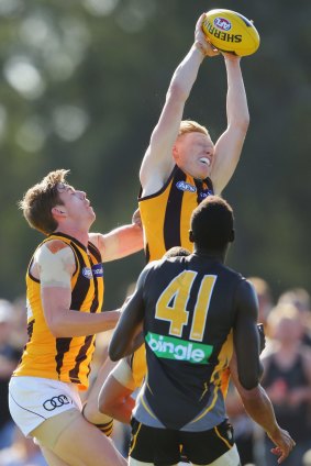 James Sicily of the Hawks grabs a mark as teammate Ryan Schoenmakers and Mabior Chol of the Tigers  watch.