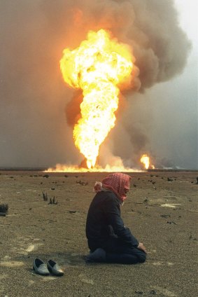 A Kuwaiti oil field worker kneels for midday prayers near a burning oil field near Kuwait City, on March 2, 1991.