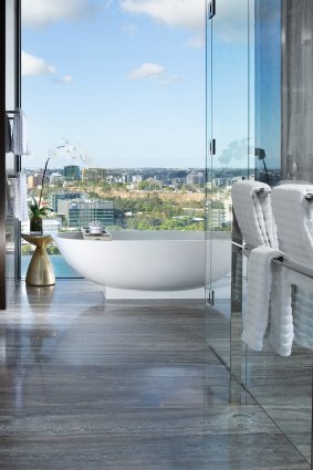 The master bedroom has an en-suite with double rain showers and a stand-alone bath looking over Brisbane's skyline through floor-to-ceiling windows.