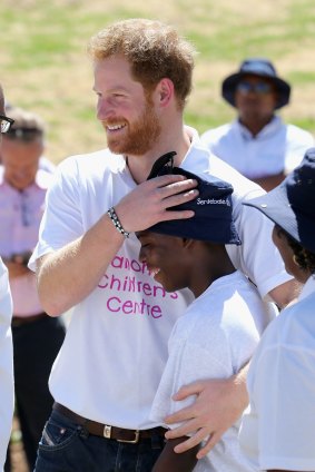 Prince Harry hugs a young boy at a centre for HIV-positive children in Maseru, Lesotho, last year. 