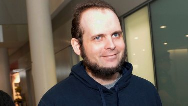 Joshua Boyle is escorted by authorities at Toronto's Pearson International Airport on the family's return in October.
