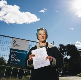 Hackett resident Tess Horwitz with a petition calling for careful development on razed Fluffy blocks in the suburb.
