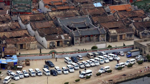 Police cars lined up outside  Boshe village, Guangdong province, during the meth raid on December 29.