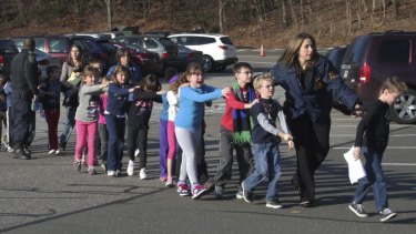 Connecticut State Police lead a line of escaping children from the Sandy Hook Elementary School in December 2012.