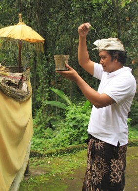 Tour guide sprinkles himself with holy water
at the meditation caves.