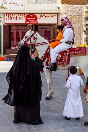 Traditionally clad police atop prancing Arabian horses in Doha's souq.