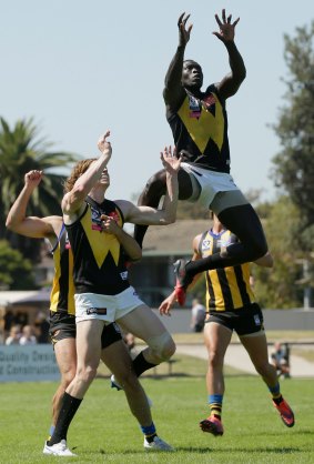 Majak Daw leaps over his North Melbourne teammate Ben Brown to mark the ball.
