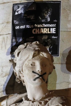 Free speech at risk: A statue at the Place de Republique with a cross spread across its mouth.