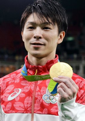 Japan's Kohei Uchimura displays his gold medal for the artistic gymnastics men's individual all-around final. 