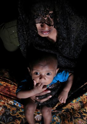 Mohsena Begum, a Rohingya who escaped to Bangladesh from Myanmar, holds her child at an unregistered refugee camp in Teknaf, near Cox's Bazar, in Bangladesh.