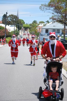 Santas fill the streets of Leederville in the Variety Santa Fun Run.