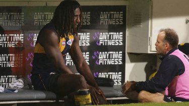 The Eagles' Nic Naitanui holds his injured knee on the bench during the match against Hawthorn on Friday night. 