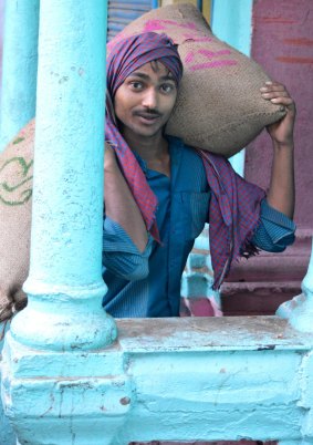 A man hauls a large sack of cayenne peppers on his back through the centuries-old spice market of New Delhi, India. 