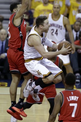 Injured: Cleveland Cavaliers guard Matthew Dellavedova goes up for a shot past Toronto Raptors rivals Cory Joseph and Kyle Lowry.