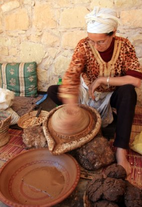 Berber woman extracting oil from Argan nut kernals at the Assous Argane oil co-operative, Souss Valley, Morocco.
