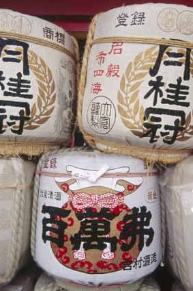 Three traditional sake barrels stacked up outside the temple wall. 