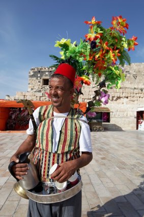 A tea vendor in traditional dress in the ancient town of Gadara.