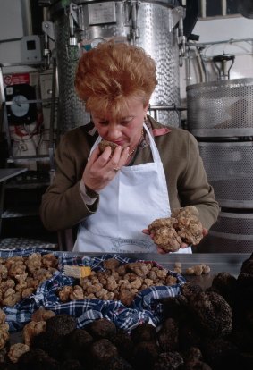 A woman smells white truffles.