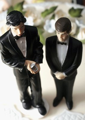 Same sex statues adorn the top of a wedding cake at a wedding specialists store in England.