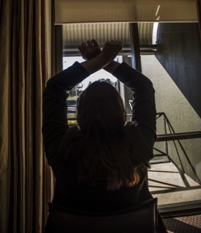 The former care worker demonstrates how the intellectually disabled woman's arms were tied above her head for 30 minutes a time while she was directed to clean the house.