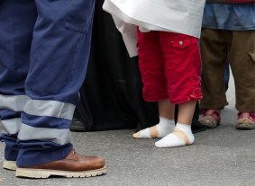 A refugee boy with bandaged feet stands beside an official after he arrived at the railway station in Munich, southern Germany.