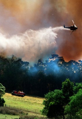 A helicopter drops water over the bushfires at Ferny Creek in 1997.