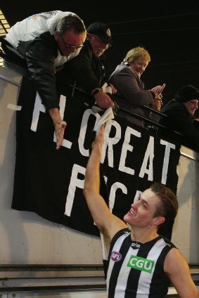Darcy Moore of the Magpies celebrates the round 22 win over Geelong with fans.