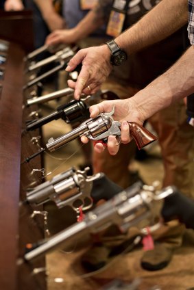 An attendee handles a revolver in the Sturm, Ruger & Co., Inc. booth at the 144th National Rifle Association Annual Meetings and Exhibits in Nashville.