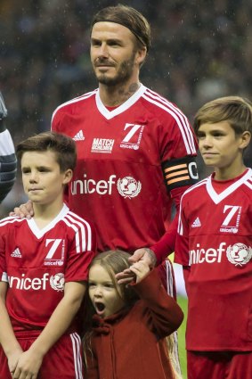 Family snap: David with son Cruz, left, Harper, bottom, and Romeo at a charity soccer game last month.