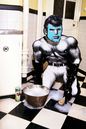 Performance artist Brenton Heath-Kerr transformed Finnish artist Tom of Finland' s Kake character into a domestic goddess scrubbing floors, satirising macho clones.