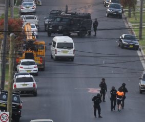 Police lead away a man whom they arrested in Lockwood Street, Merrylands.