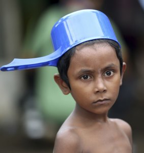 A Rohingya child prepares to take a shower at a temporary shelter in Bayeun, Aceh province, Indonesia on Saturday.