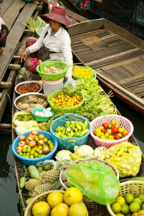 A floating market brings fresh produce to the settlements along the edge of the lake.
