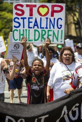 Marchers protest the removal of indigenous children from their families.
