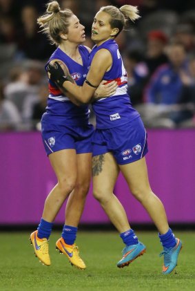Jessica Wuetschner and Moana Hope of the Western Bulldogs celebrate a goal during a women's AFL exhibition match against Melbourne at Etihad Stadium in August 2015.
