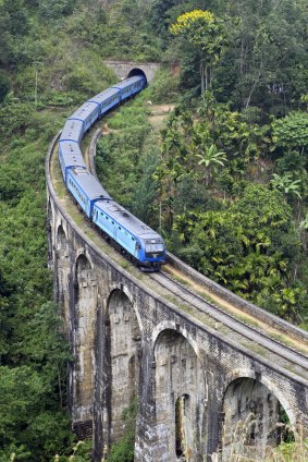 Rail tale: A modern passenger train swoops down over one of Sri Lanka's old bridges.