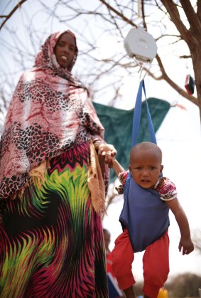 Kawsar Muhumed and her baby daughter Moraw being weighed at the Somali Red Crescent mobile clinic.
