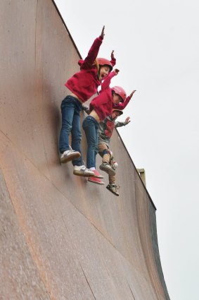 Chloe, Aaliyah and Keefer Wilson free fall down the steep six-metre drop on a giant skateboard ramp.