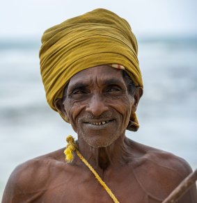 A stilt fisherman wearing a traditional Sri Lankan headdress.