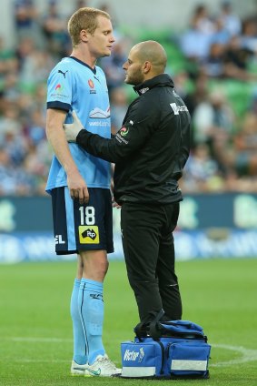Matt Simon of Sydney FC is attended to by a trainer after he was substituted during the game against Melbourne Victory.