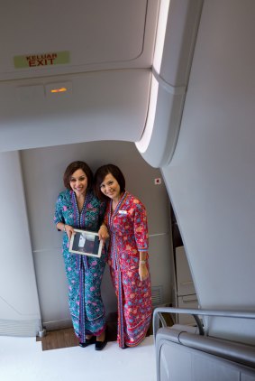 Malaysia Airlines cabin crew at the bottom of the A380 staircase.